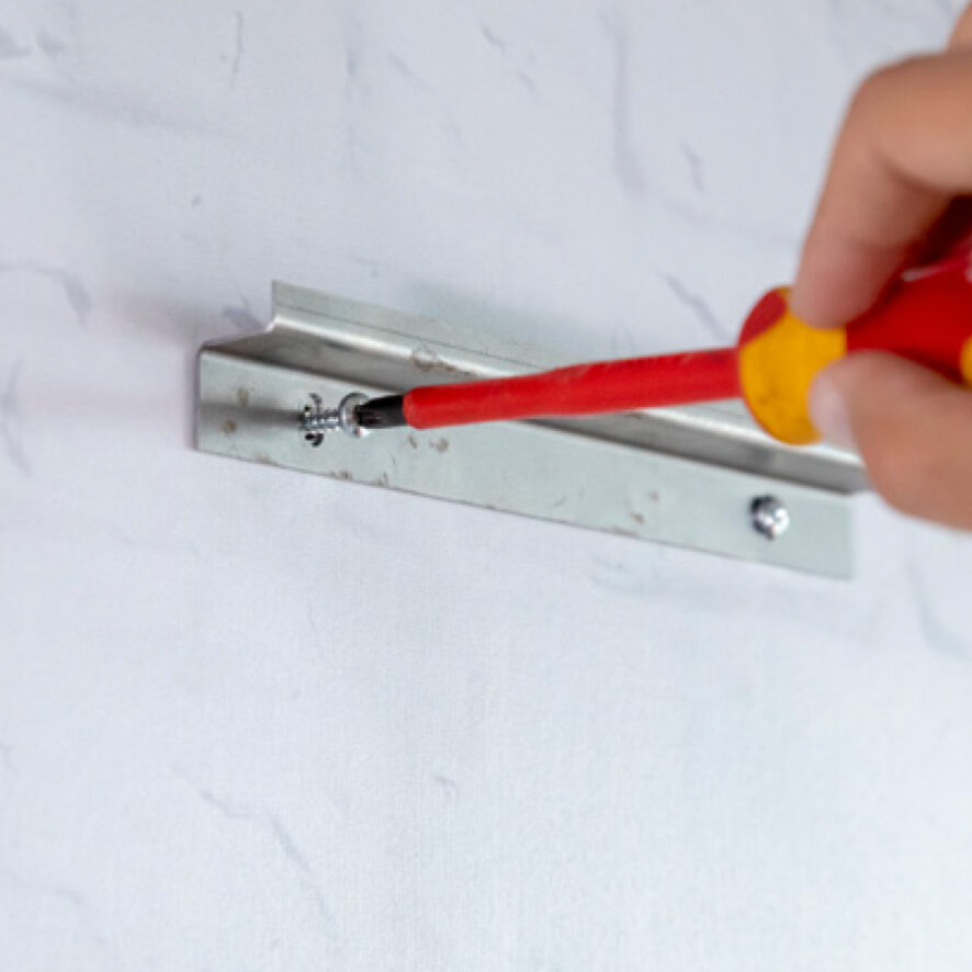 push a plug into each drill hole and screw the Z-profile to the wall.